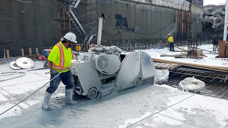 Graff team member using saw to cut through concrete