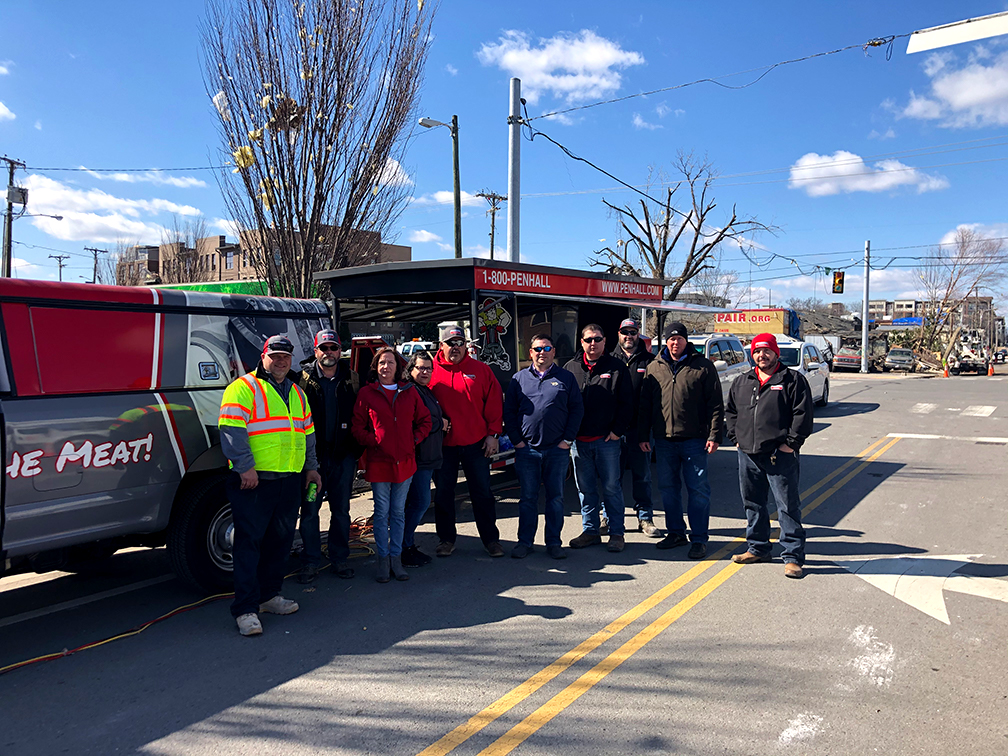 Penhall Team standing with grill after Nashville storms and Tornado